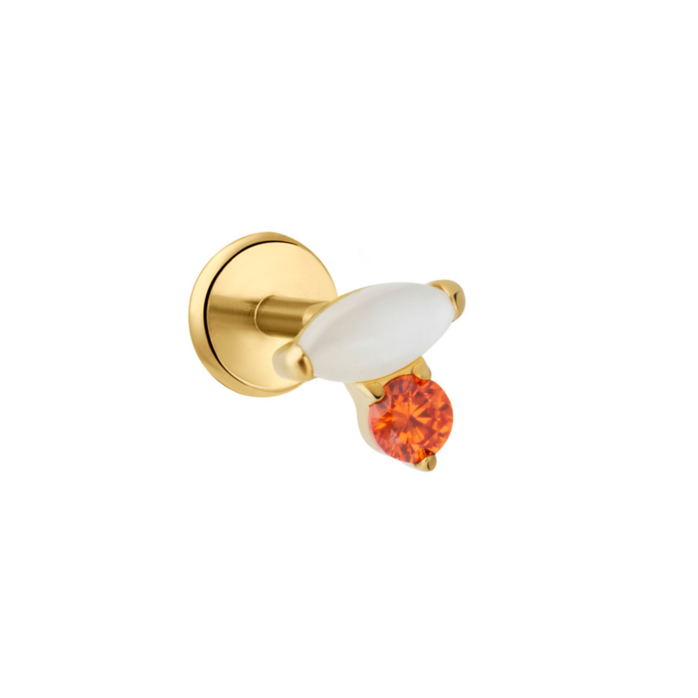 A gold flat back stud with a white oval gem and a round orange gem, shown against a plain white background.