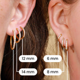Comparison of 6 different sizes of gold hoops on the ears of 2 models.