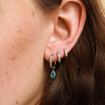 Close-up of an ear wearing multiple earrings with a blurred background