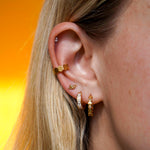 Close up of a model wearing a cuff earring made from stacked hexagon shapes. Hoop made from stainless steel.