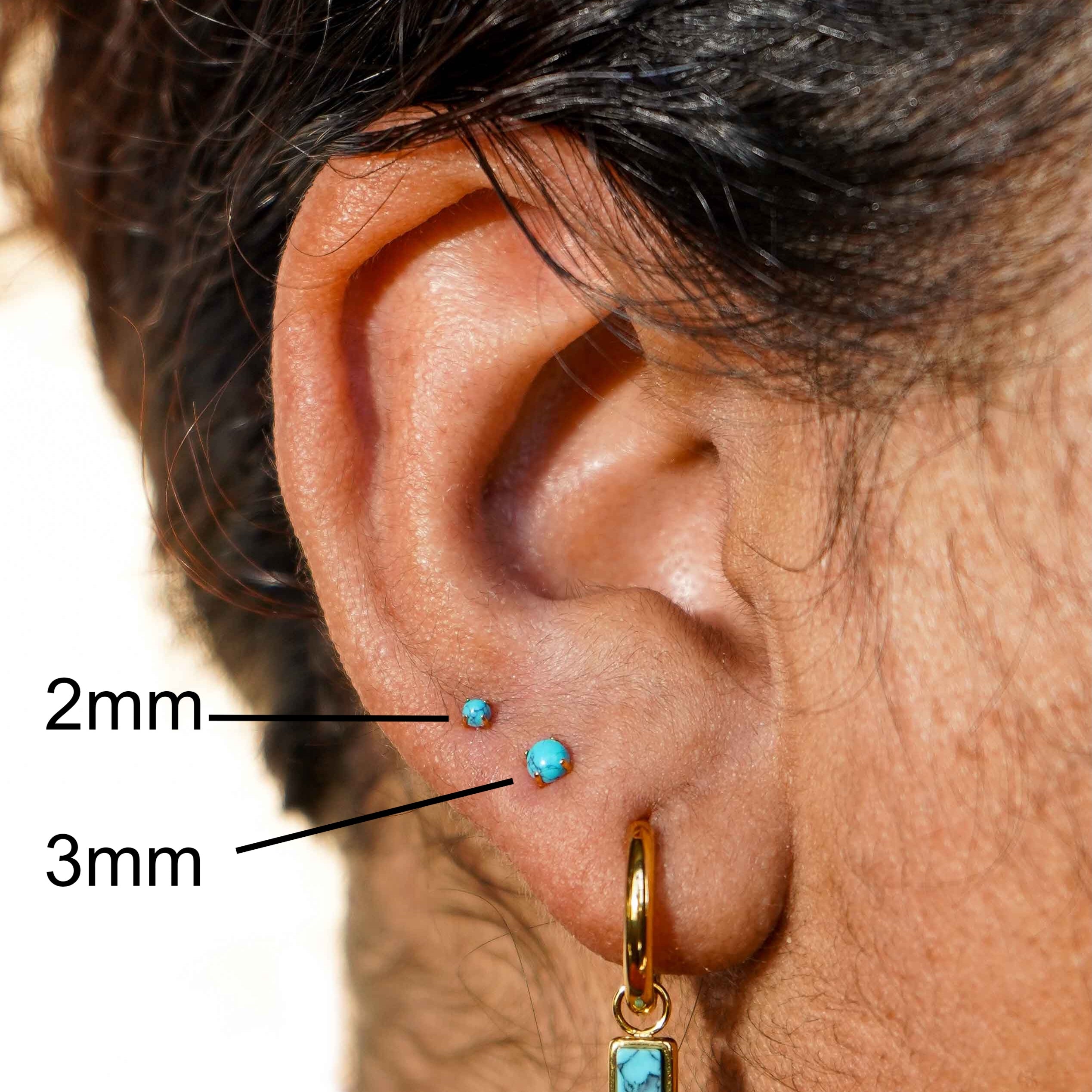 Close-up of an ear with a turquoise earring, showing sizes 2mm and 3mm.