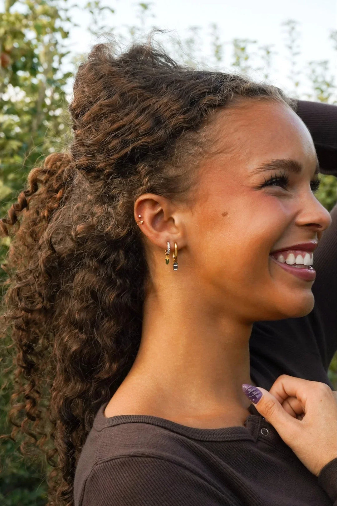 Woman with curly hair smiling outdoors