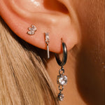 Close-up of an ear wearing multiple earrings with a blurred background