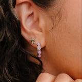 Close-up of an ear wearing a colorful earring with a blurred background