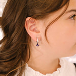 Close-up of a person wearing an earring with a blurred background