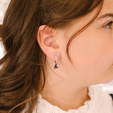 Close-up of a person wearing an earring with a blurred background