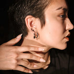 Side profile view of model showing of silver and black earring stack