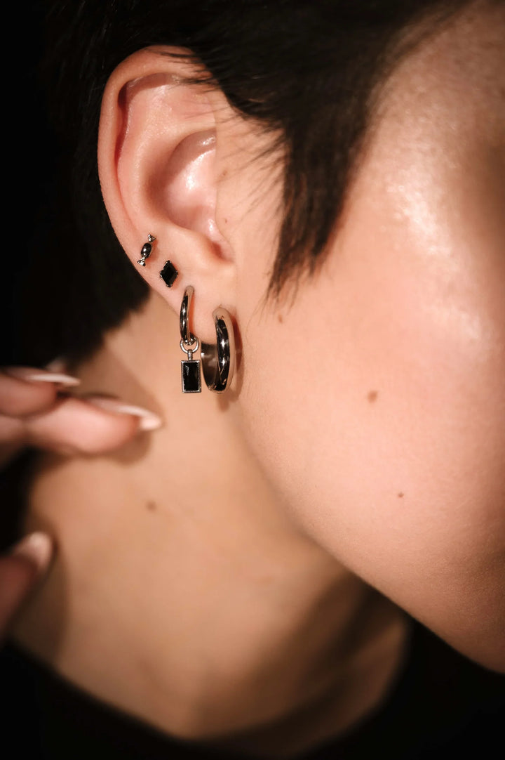 Silver and black earring stack featuring flat backs and hoop styles