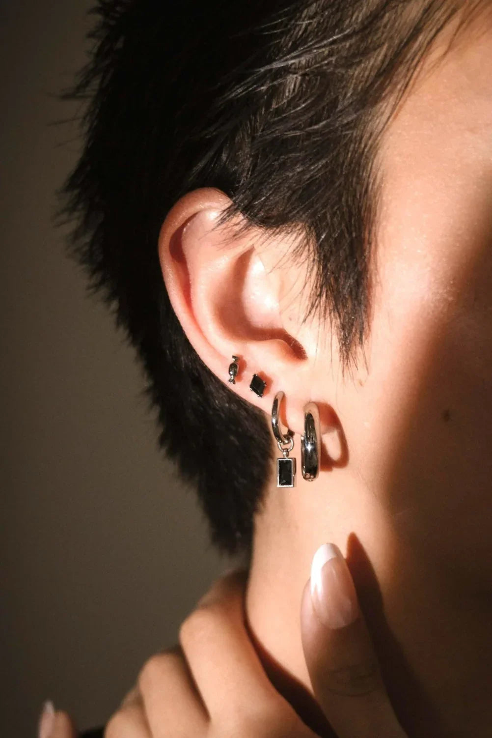 Close up ear shot of black and silver earrings
