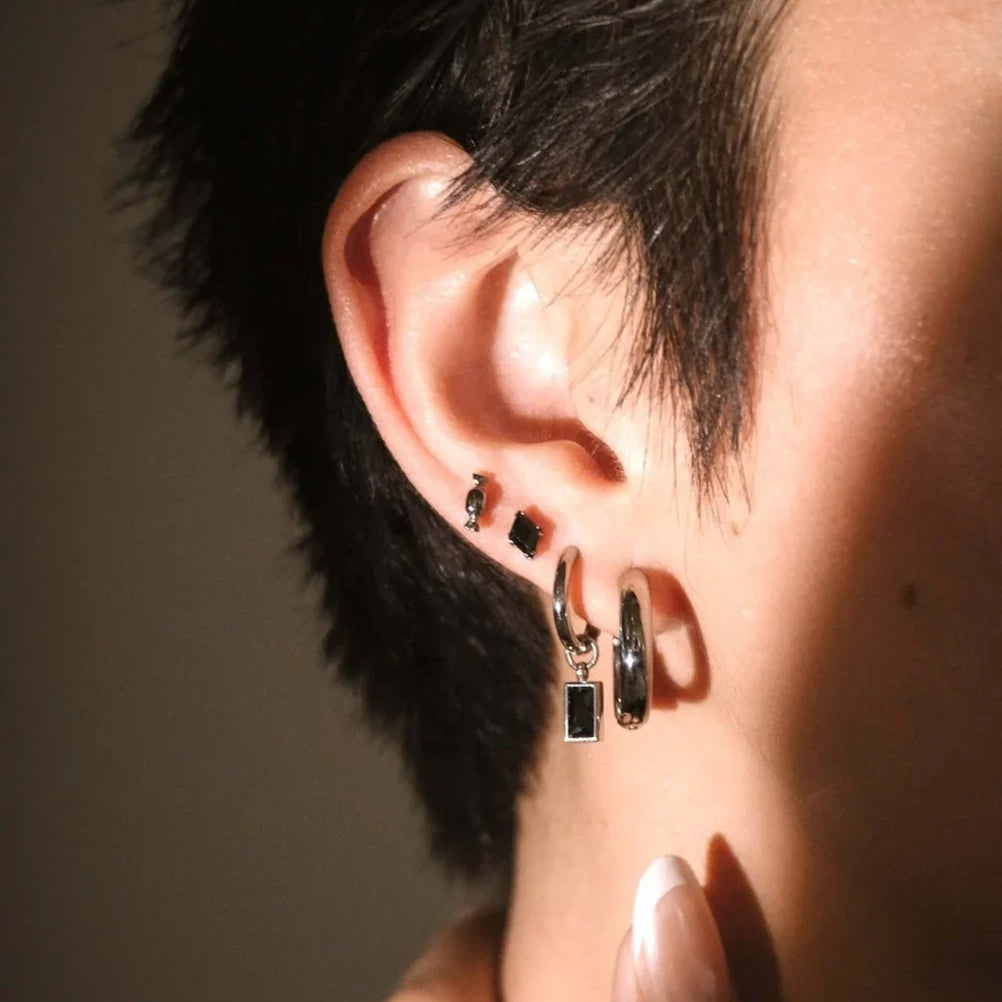Close up ear shot of black and silver earrings