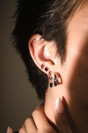 Close up ear shot of black and silver earrings