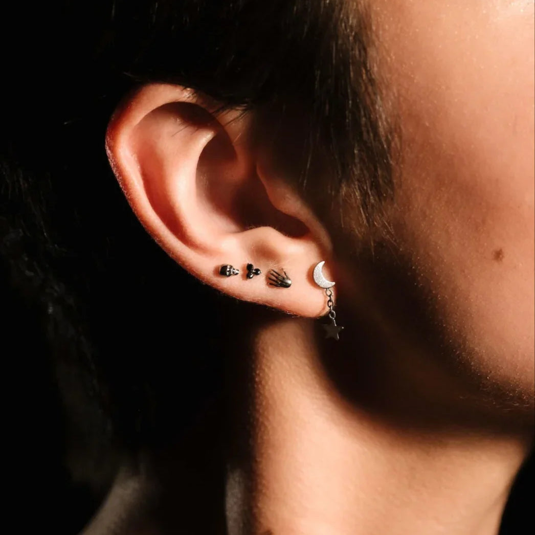 Close up of an ear with black and silver flat backs