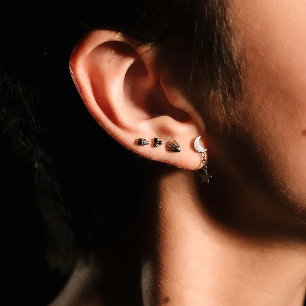 Close up of an ear with black and silver flat backs