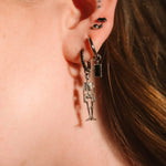 Close up of an ear with black and silver flat backs and hoops