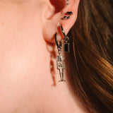Close up of an ear with black and silver flat backs and hoops