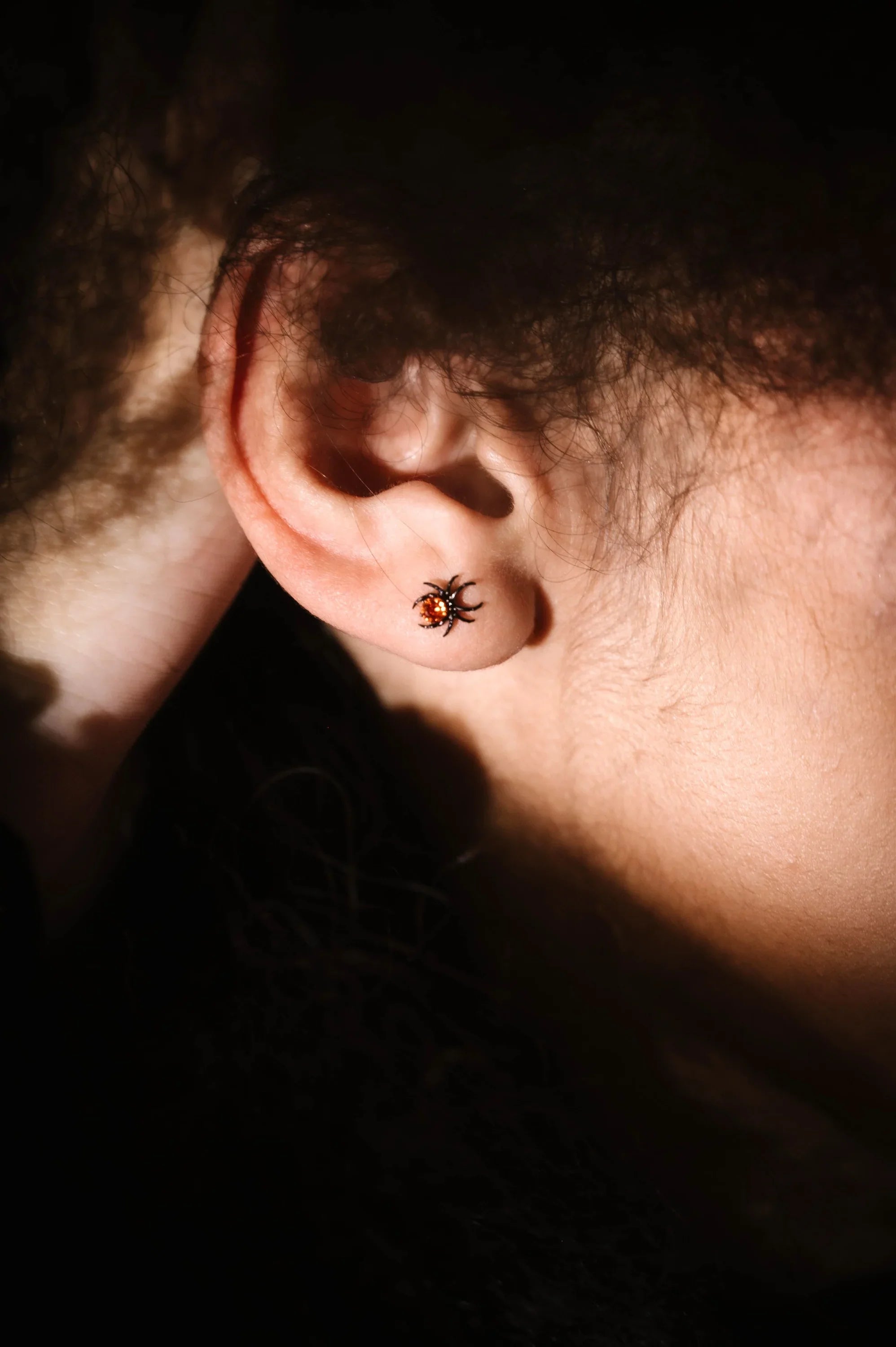 close up photo of an ear wearing a spider flat back