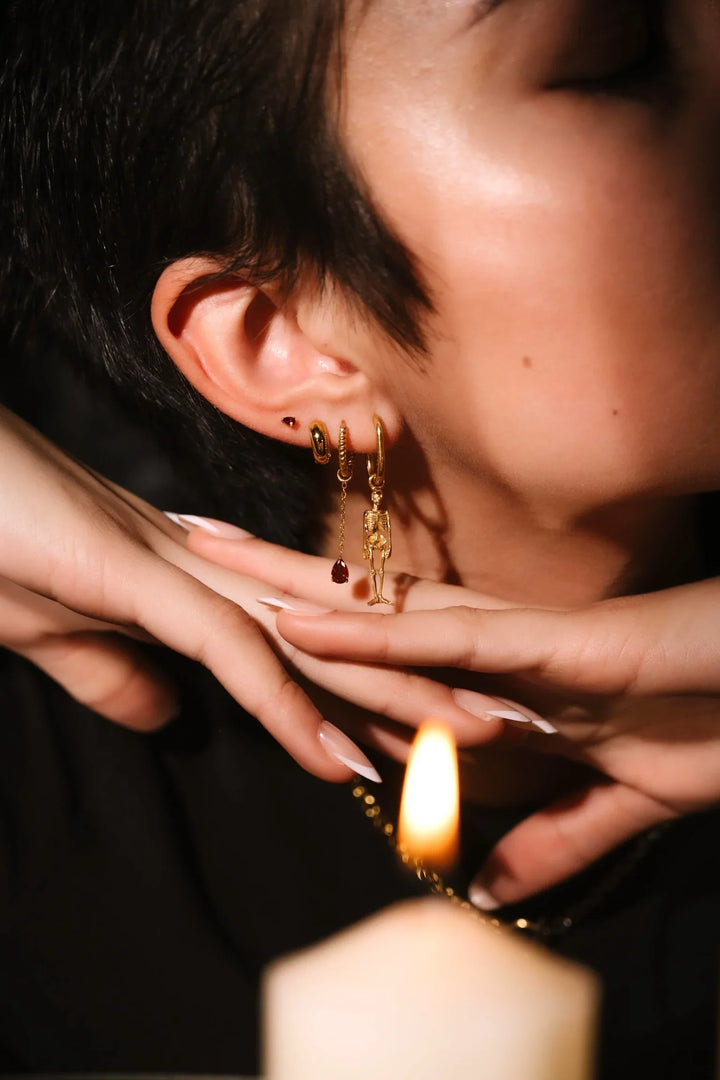 Close up of an ear with black and gold flat backs and hoops