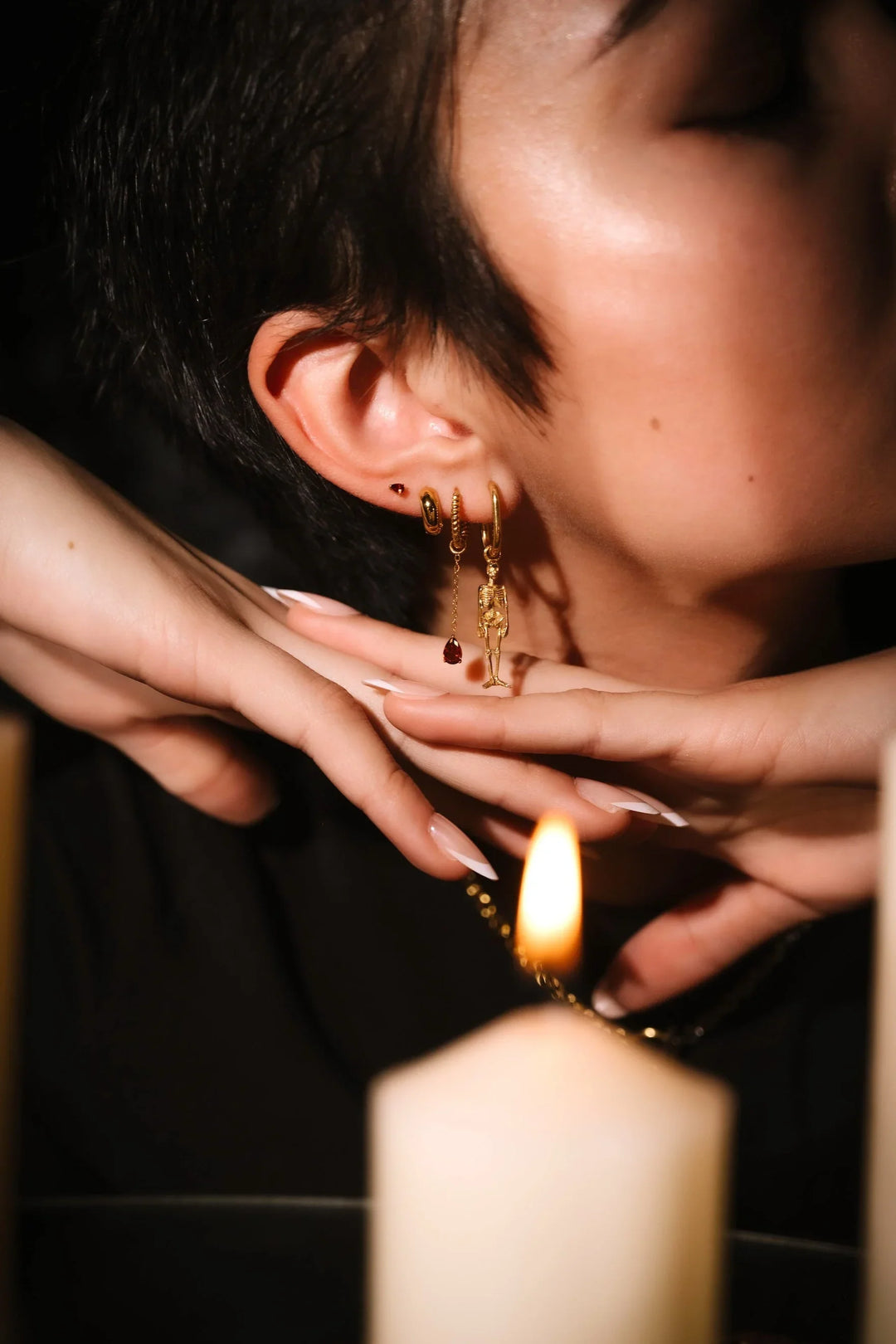 Close up of an ear with black and gold flat backs and hoops