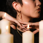 Close up of an ear with black and gold flat backs and hoops