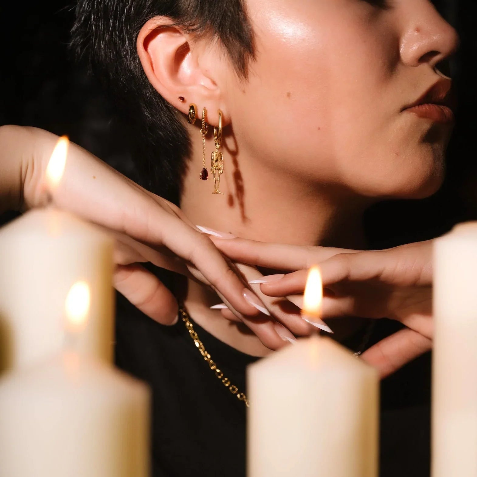 Close up of an ear with black and gold flat backs and hoops
