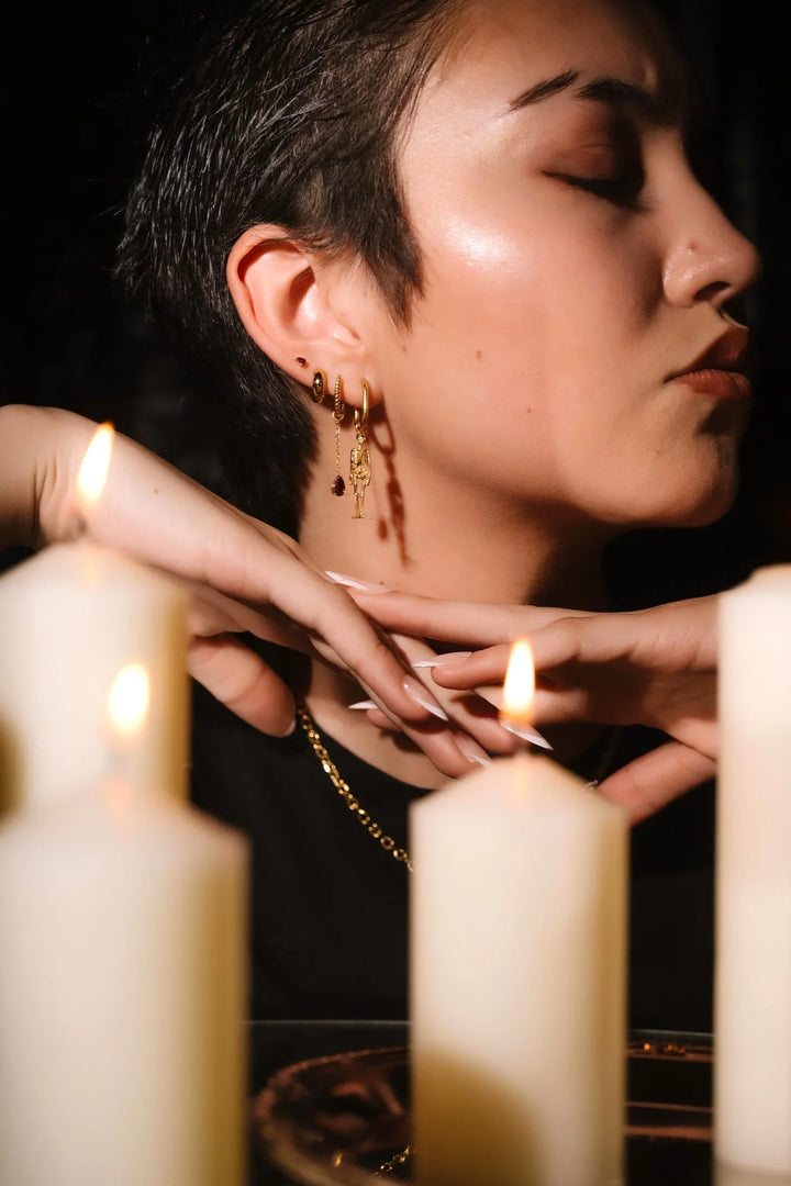 Close up of an ear with black and gold flat backs and hoops