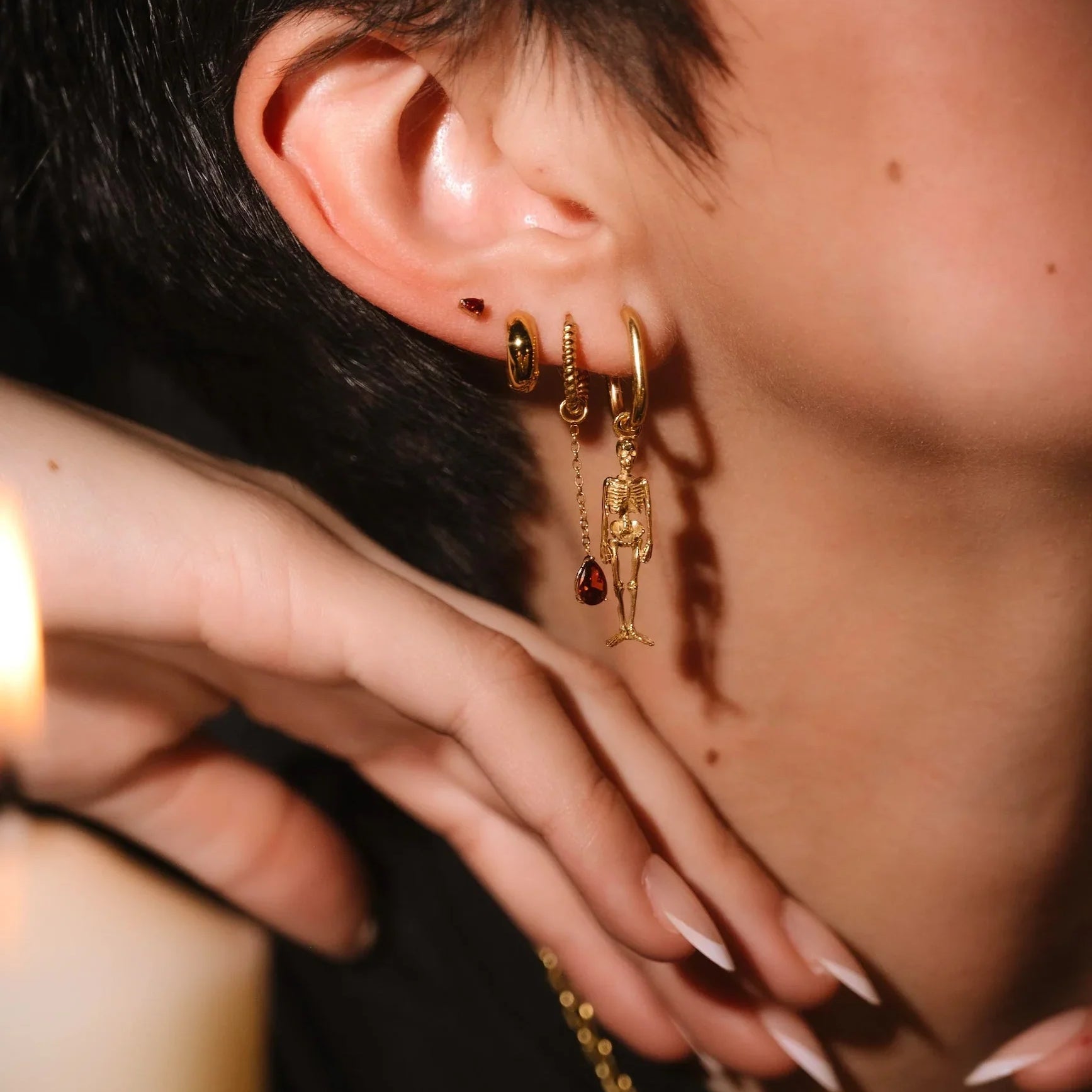 Close up of an ear with black and gold flat backs and hoops