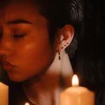 Profile shot of a model wearing garnet hoops and gold flat backs