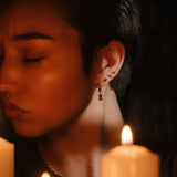 Profile shot of a model wearing garnet hoops and gold flat backs