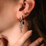 Close up of on ear wearing silver and black earrings