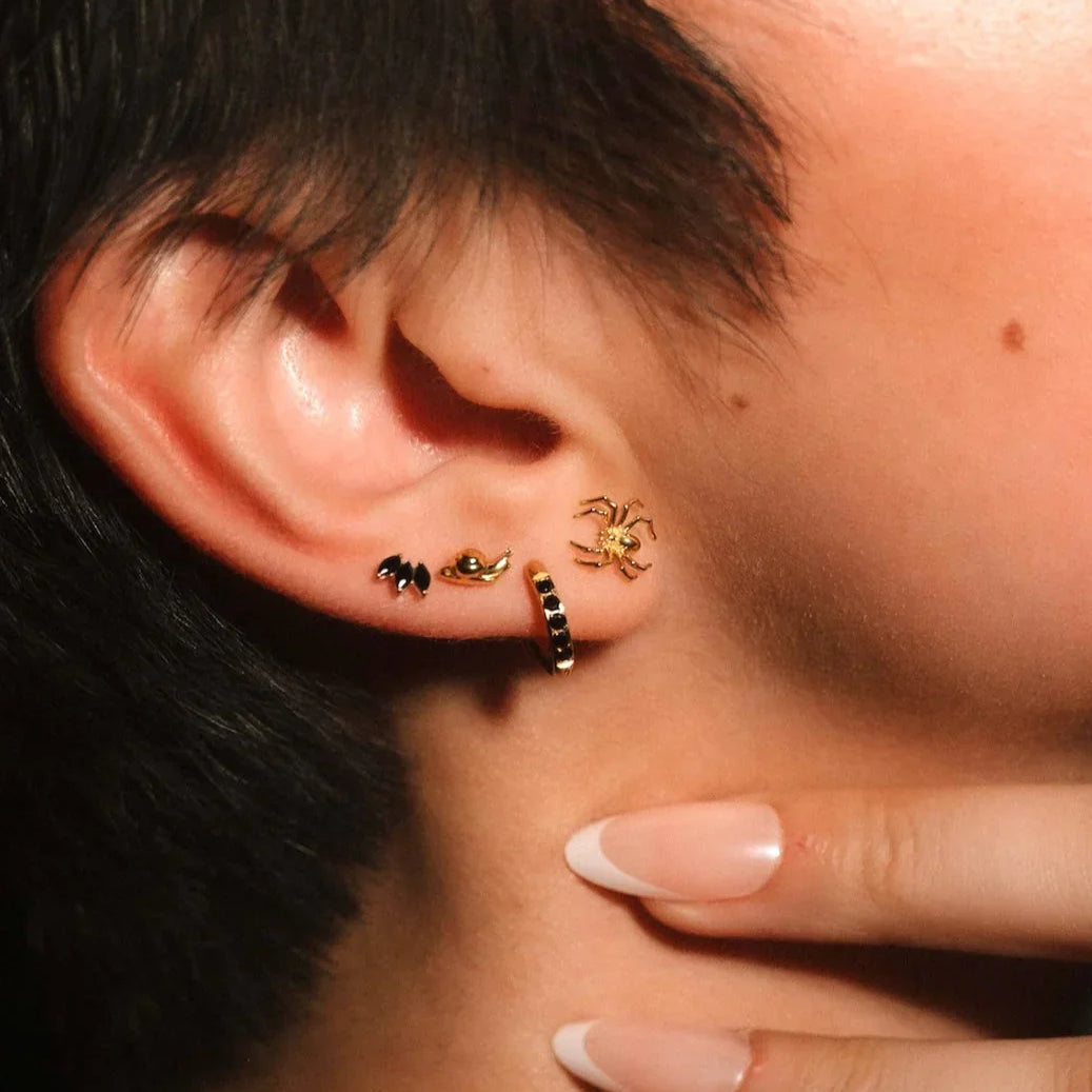 Close up of an ear with gold and black flat backs and hoops