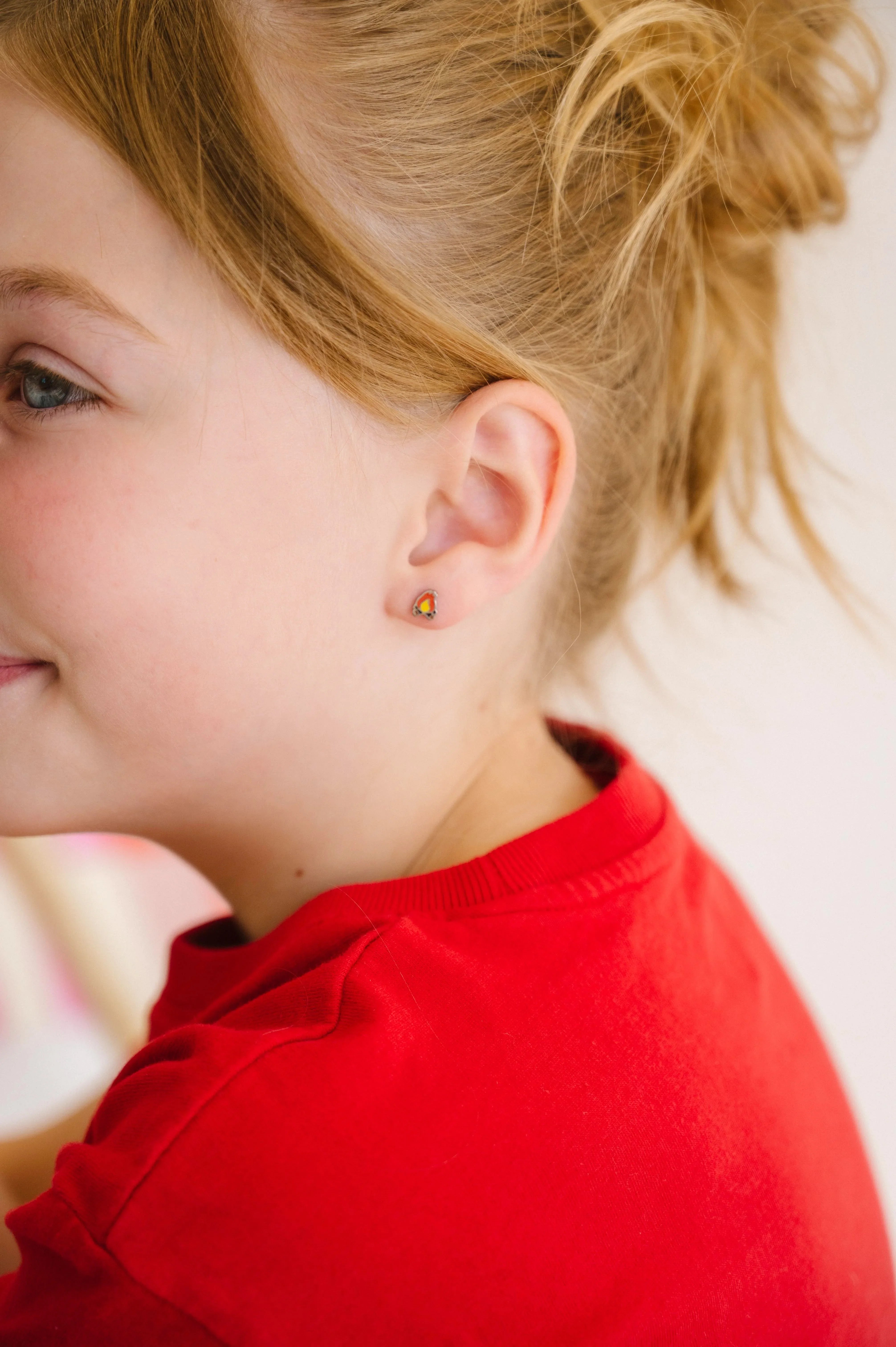 Close-up of a child wearing a red shirt with a blurred background