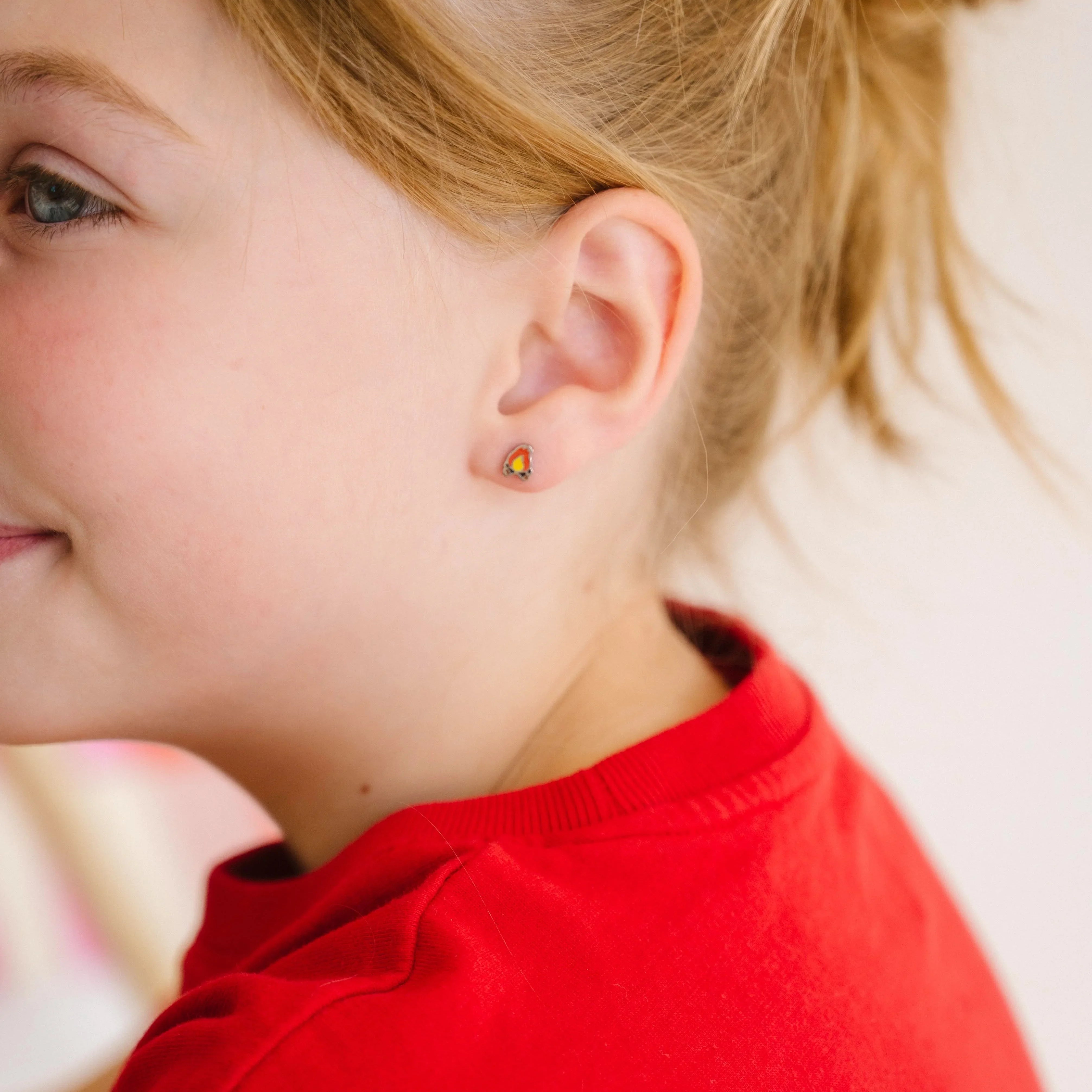 Close-up of a child wearing a red shirt with a blurred background