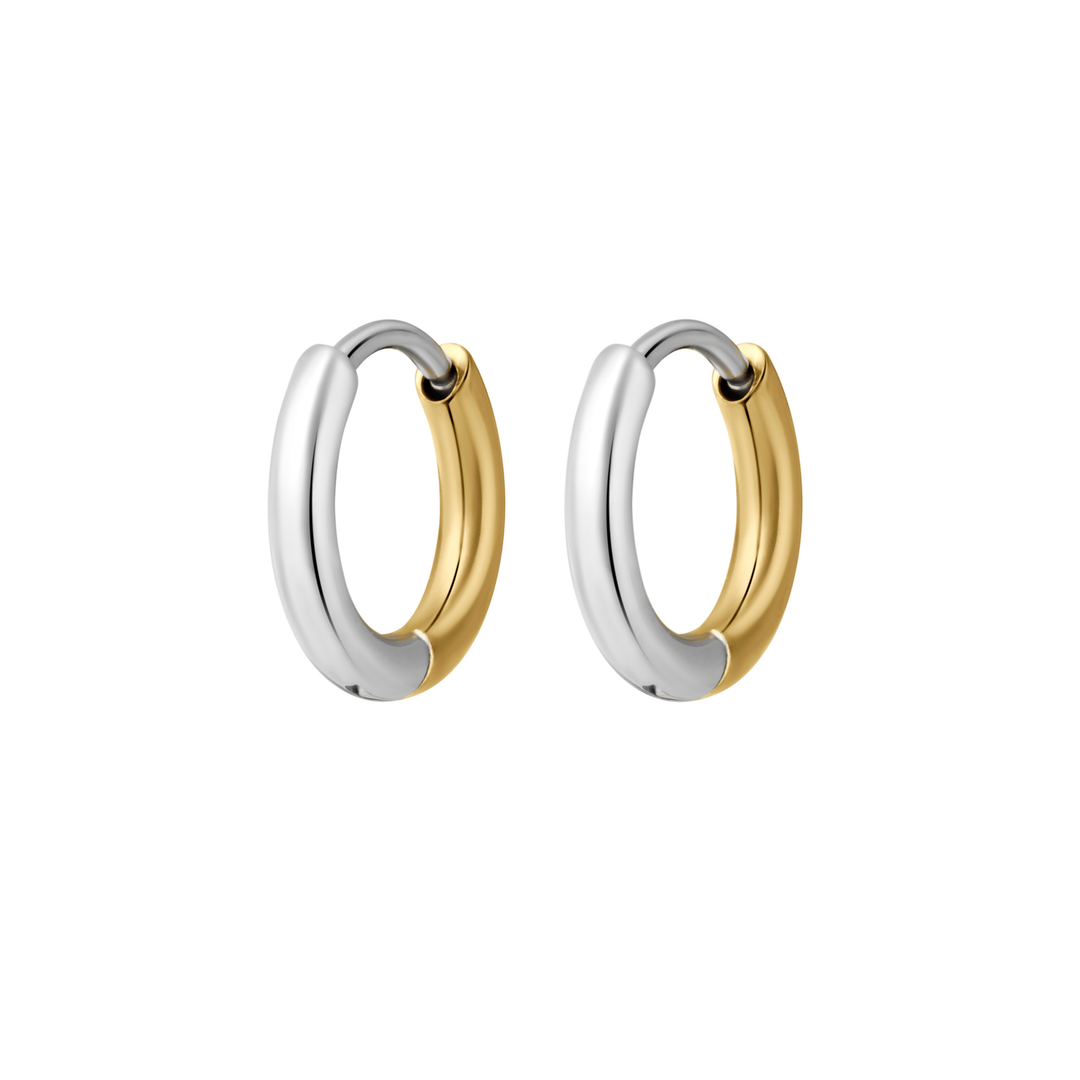 A close up of a pair of hoop earrings that feature a split design where one half of the hoop is silver in color and the other is gold. Hoops are made from ASTM F136 Implant Grade Titanium and the gold half is finished with 18k Gold PVD plating.