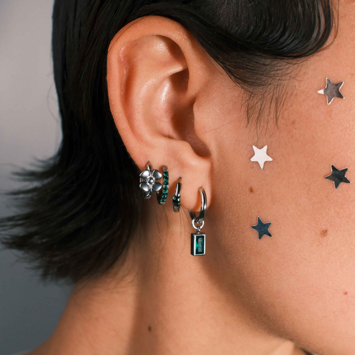 Close-up of an ear with multiple earrings 