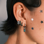 Close-up of an ear with multiple earrings 