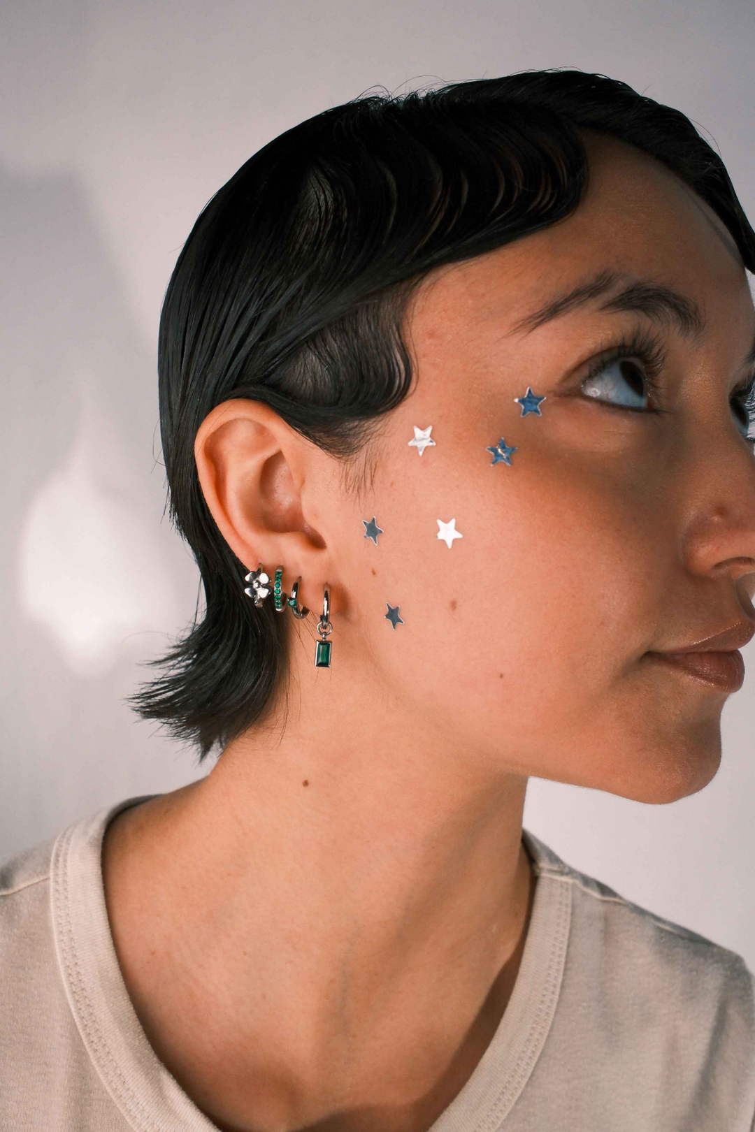 Close-up of an ear with multiple earrings 