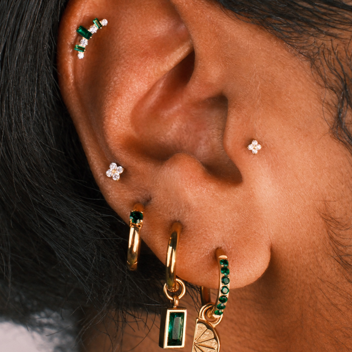 Close up of an ear with multiple earrings