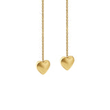 Zoomed-in view of gold heart-shaped threader earrings on a white background