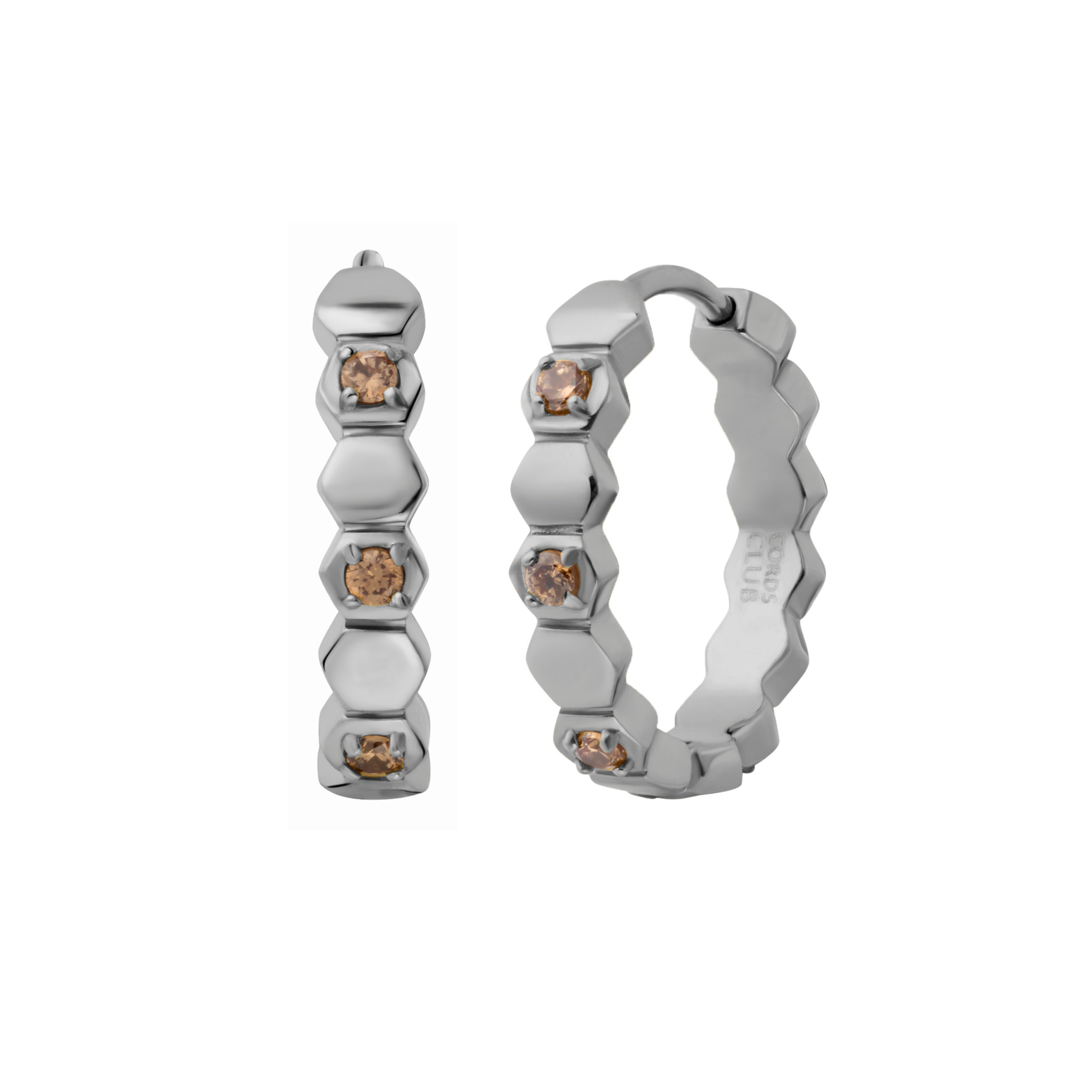 Close up of a hoop earring made from stacked hexagon shapes with a honey colored zirconia stone set into every other hexagon shape. Hoop made from 316L Surgical Steel with a honey-colored zirconia stone, set onto every other hexagon, against a blurred background.
