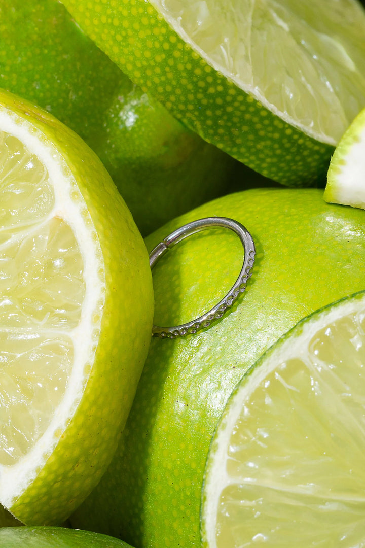 Close-up of sliced limes with a silver cartilage hoop on top