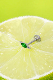 Lime wedge with a silver flat back stud earring featuring a green marquise gemstone on a green background