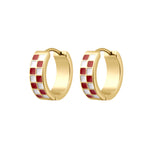A pair of gold huggie hoop earrings with a checkered red and white enamel pattern, shown on a plain white background.