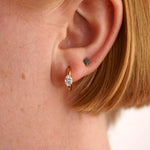 Close-up of a person's ear wearing two earrings.