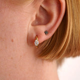 Close-up of a person's ear wearing two earrings.