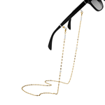 Gold eyeglass chain attached to black sunglasses on a white background