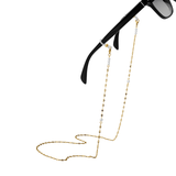 Gold eyeglass chain attached to black sunglasses on a white background