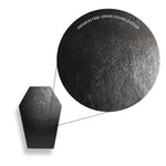 Close-up of a black vegan leather product with texture details on a white background