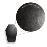 Close-up of a black vegan leather product with texture details on a white background