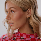 Woman wearing a red checkered shirt with owl pattern against a white background