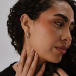 Woman wearing a diamond earring with a neutral background